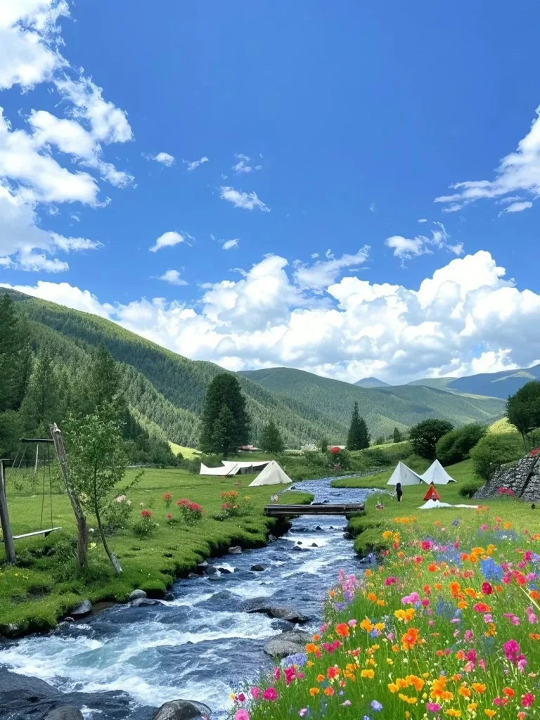 A scenic mountain valley in China featuring a winding river, lush green grass, and colorful wildflowers. Several white camping tents are set up on the riverbanks, with a small wooden bridge crossing the water. Rolling hills covered in trees are in the background under a blue sky with white clouds.